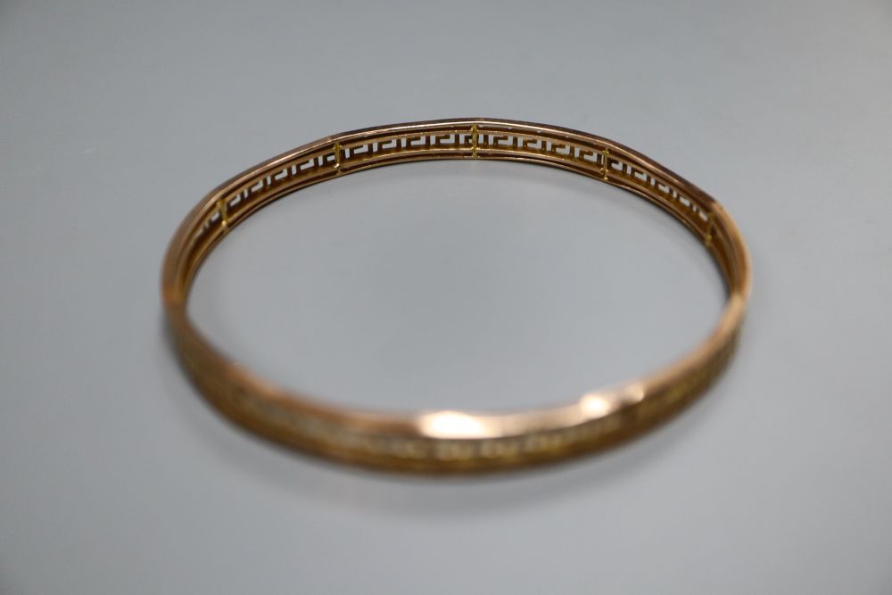 A 9ct bangle with pierced Greek key border, 12.8 grams.